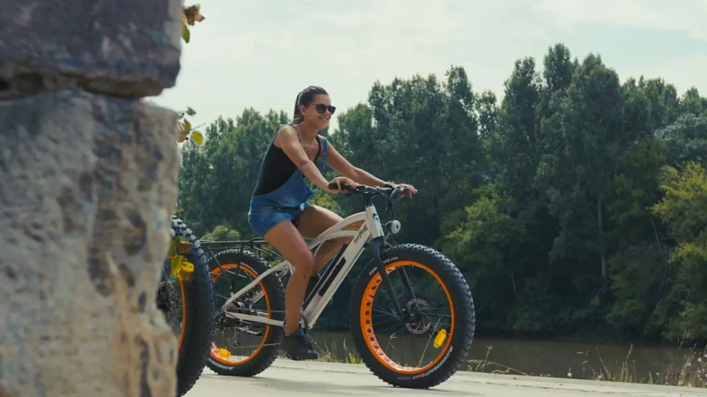 Une jeune femme se promène à vélo sur les bords de l'Adour à Saubusse