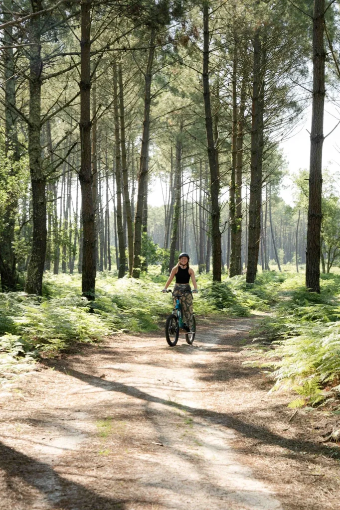 Une jeune femme fait de la trottinette électrique dans les chemins landais