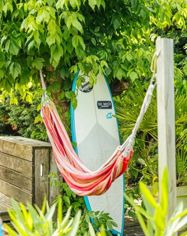 Hébergement surf dans les Landes, jardin avec hamac et planche de surf