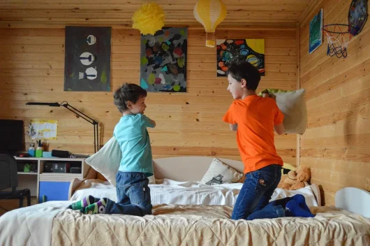 enfants jouant sur un lit