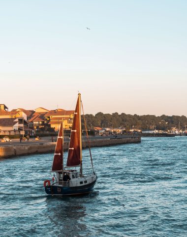 Un voilier rentre au port de Capbreton au coucher de soleil