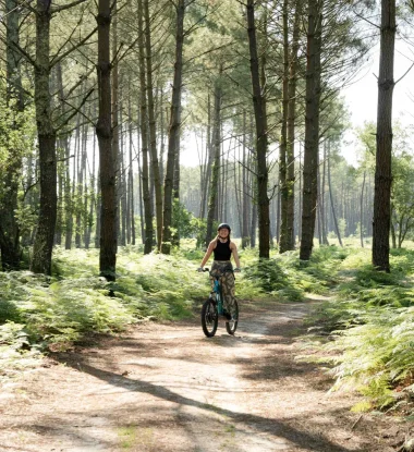 Une jeune femme fait de la trottinette électrique dans les chemins landais