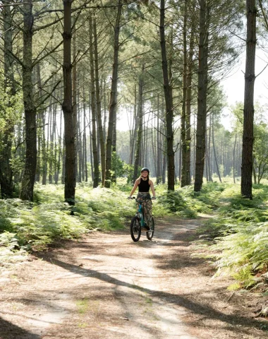 Une jeune femme fait de la trottinette électrique dans les chemins landais